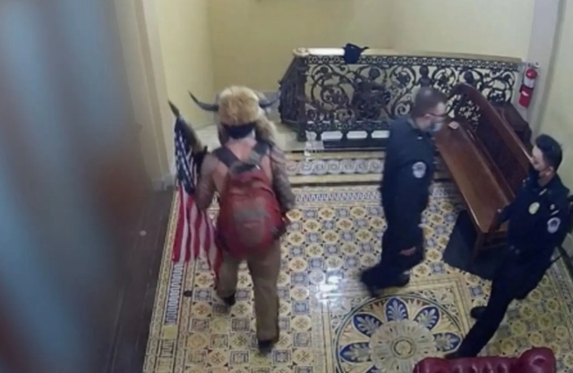 Image: Capitol surveillance video shows ‘QAnon Shaman’ being escorted through building by police, not ‘leading an insurrection’